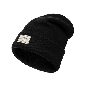Black knit beanie with New York embroidery patch shown in a 45-degree side view