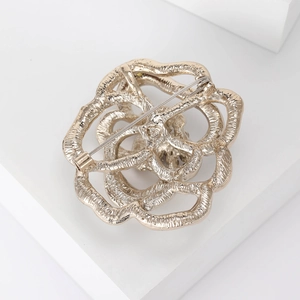 Detailed back view showing the gold flower brooch pin and secure clasp closure