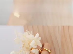 Dettaglio di bracciale con ciondolo quadrato placcato oro 18K stile minimal