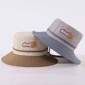 Detailed embroidery of smile face and letters on patchwork cotton bucket hat for kids