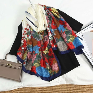 Close-up of lightweight floral patchwork scarf over black top on a white bedding