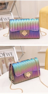 Close-up of rainbow gradient woven texture on shoulder bag with golden chain and clasp