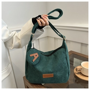 Detail of dark green corduroy tote bag with round coin purse and fashion leather label
