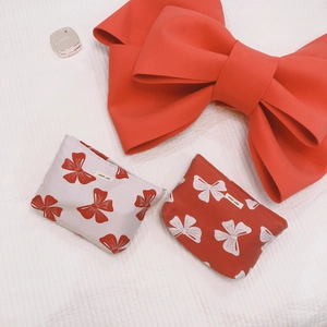 Red bow canvas makeup bag set with simple wish label on quilted background