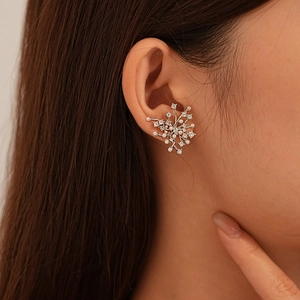 Elegant silver flower earrings with zircon and pearl accents shown on a model