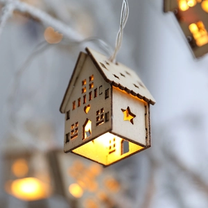 Wooden Christmas house string lights with warm LED glow and laser-cut star patterns