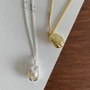 Detail of S925 sterling silver pearl pendant and hammered texture gold necklace
