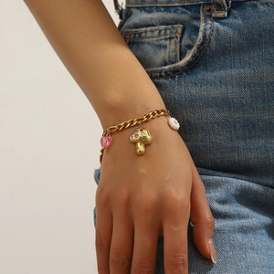 Gold-plated chain bracelet featuring crystal mushroom, pink heart, and floral charms