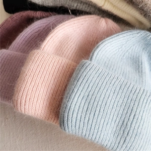 Close-up of plush rabbit fur knit beanies showing thick texture in multiple pastel colors