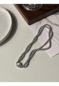 Detailed macro view of gray double-layer pearl necklace with a square shell buckle