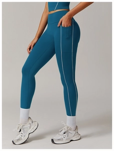 Detalle de leggings de cintura alta azul pavo real con bolsillo lateral y ribete