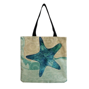Beige canvas tote bag with teal gradient starfish print and black handles