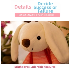 Close-up of plush rabbit toy with long ears, dark eyes, and pink striped sweater