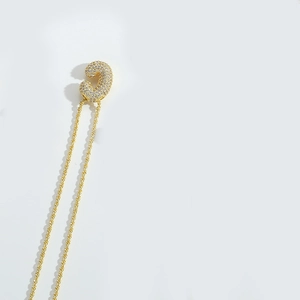 Detail of gold necklace with bubble style pendant set with white zircon crystals