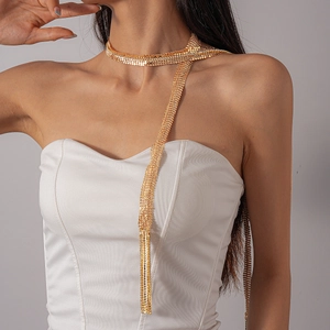 Detail view of a luxury gold mesh fringe necklace with rhinestones and long tassel drop