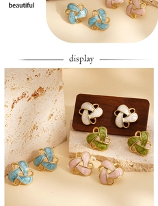 Gros plan de boucles d'oreilles géométriques vintage en émail bleu, blanc, vert et rose