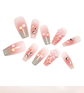 Detailed view of pink gradient press-on nails with 3D tulips and sparkling rhinestones