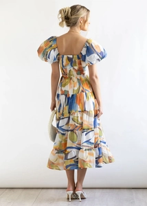 Detail view of puff sleeves and open back on a colorful abstract print off-shoulder dress