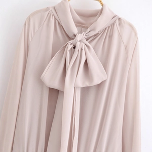 Elegant nude pink chiffon dress featuring long sleeves and a large statement bow neckline