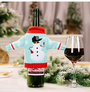 Close-up of blue knitted wine bottle cover with snowman pattern for Christmas decor