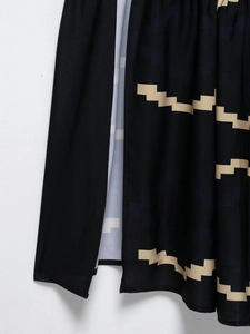 Détail de la fente latérale sur une robe française bleue à motif géométrique