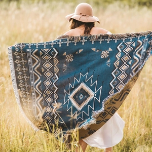 Bohemian geometric pattern picnic blanket with tassels in an outdoor field setting