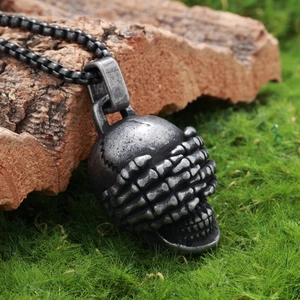 Gothic skull pendant necklace on green moss background with detailed vintage finish