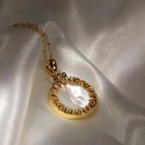 Vintage sunburst gold necklace with mother of pearl pendant on elegant satin fabric