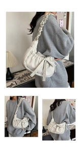 Detail of cream pleated nylon hobo bag featuring large bow and ruched shoulder strap