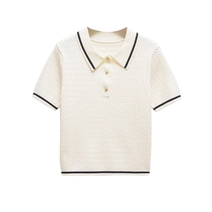 Close-up of cream knit polo shirt with black contrast trim and gold button details