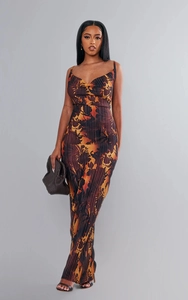 Detail of pleated fabric texture on a slim fit maxi dress with orange floral print
