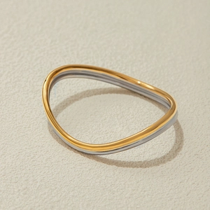 Dettaglio del bracciale bicolore oro 18K e argento con design ondulato in acciaio inox