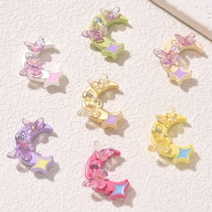 Macro shot of colorful moon and butterfly nail art charms in pastel macaron shades