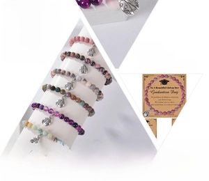 Detail of natural agate bracelets with ladybug charms on 2026 graduation gift cards
