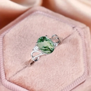 Elegant 925 silver ring with oval green moss agate and hollow heart details in a jewelry box