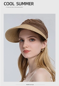 Detail of hand-woven straw brim and dark brown pleated fabric on an open top sun hat