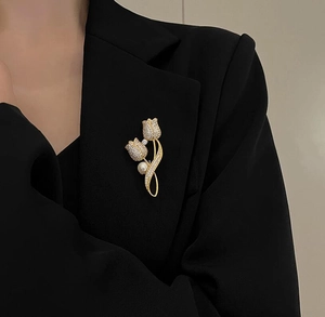 Detail of tulip brooch with rhinestones and white pearl pinned on a black suit jacket