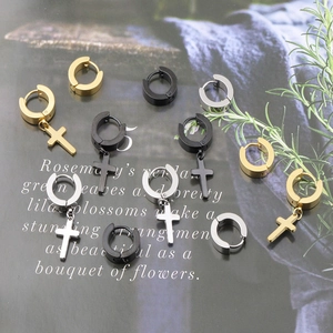 Detail view of gold, black, and silver stainless steel cross earrings set on card