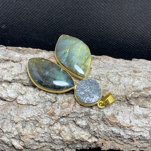Close-up of gold plated labradorite and agate pendant on a natural tree bark background