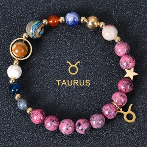 Detailed close-up of a Taurus natural stone beaded bracelet with gold zodiac charm