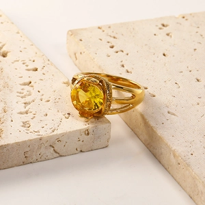 Close-up of 18K gold-plated titanium ring with yellow zircon on stone background