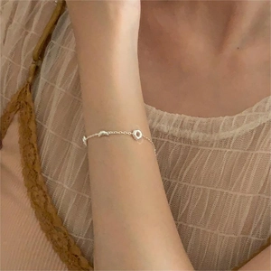 Close-up of a S925 sterling silver geometric bracelet on a woman's wrist with lace