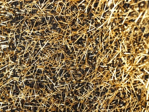 Macro detail of French style bomber jacket showing gold metallic threads on black knit