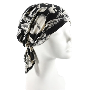 Women's pre-tied turban hat with black and white floral print on a mannequin
