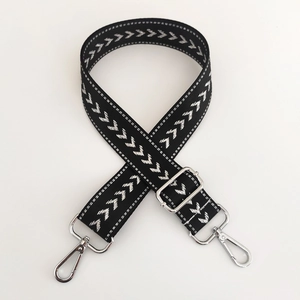 Close-up of black nylon strap with white arrow pattern and silver metal buckle
