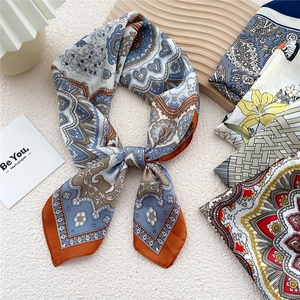 Elegant paisley and floral silk scarf for women displayed with vintage accessories