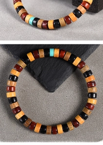 Macro shot of colorful wooden tube beads and turquoise accent on an elastic bracelet