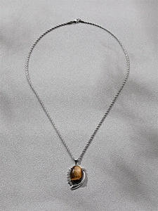 Detail of silver twist chain and heart pendant with brown tiger eye stone and diamond accents