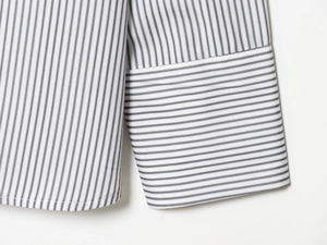 Close-up of the striped poplin shirt cuff and hem with premium stitching details