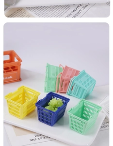 Dettaglio di mini cesti della spesa colorati e cassette di bevande con uva giocattolo